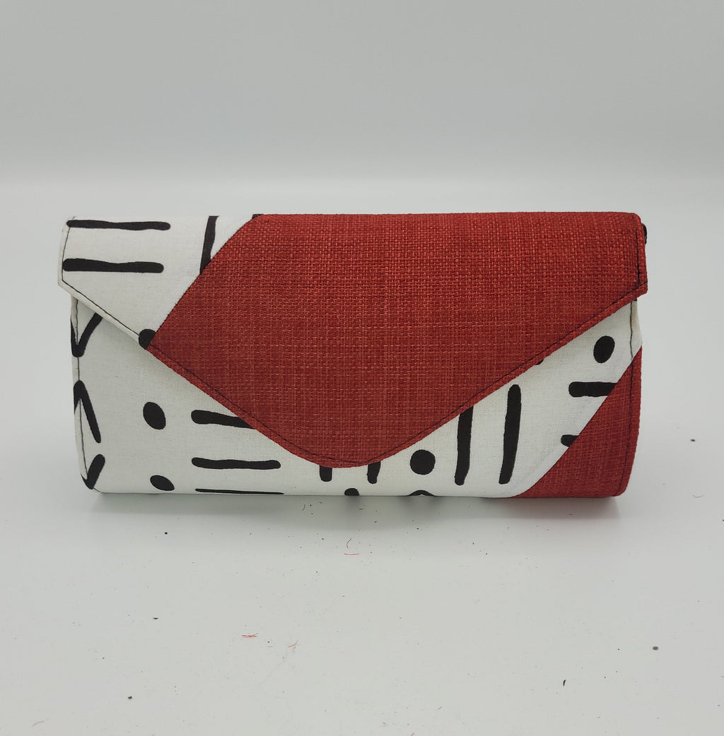 “Senegal cotton canvas shoulder clutch with red flap and black geometric pattern, front view.”